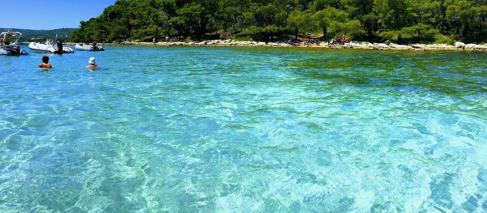 Swimmers in a glass-clear turquoise cove