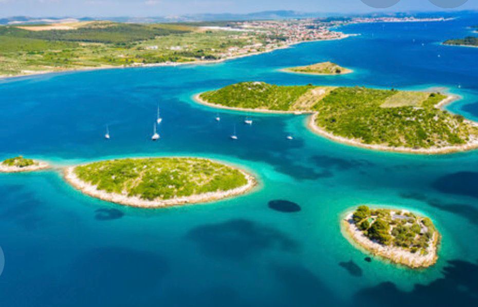Adriatic archipelago dotted with sailboats, a coastal town beyond