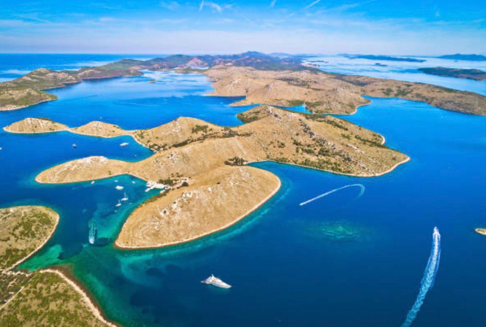Golden Kornati islands from the air, bare stone ridges over deep blue channels
